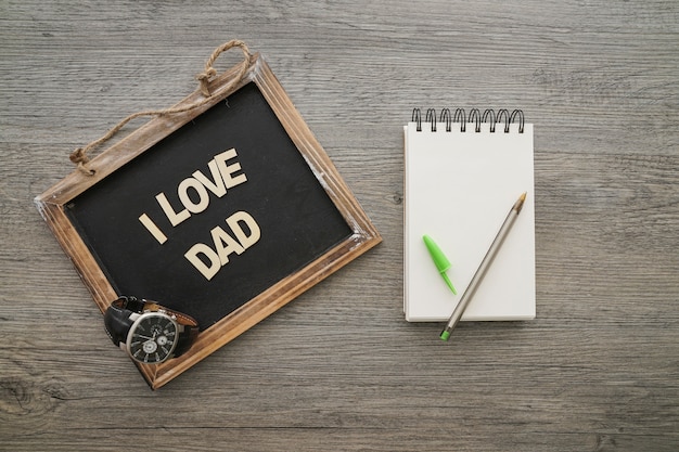 Free photo top view of father's day composition with slate and notebook