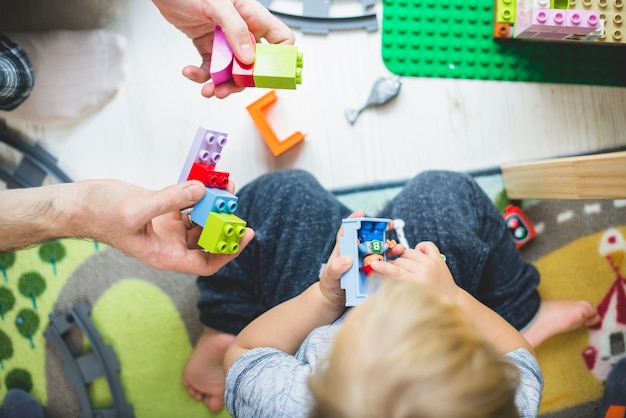 Foto gratuita vista dall'alto di padre e figlio che giocano con pezzi colorati
