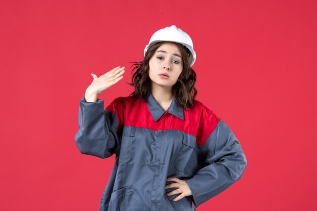 Free photo top view of female builder in uniform with hard hat and troubling on isolated red background