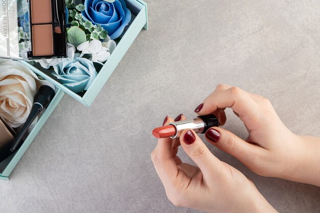 Top view of female hands holding lipstick. 