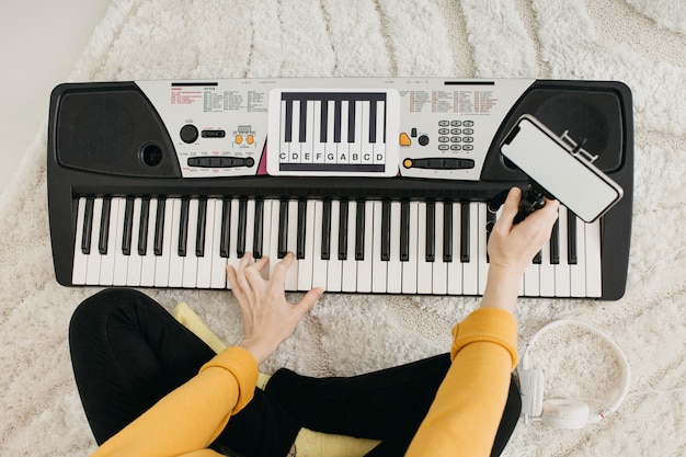 Top view of female musician blogger streaming at home with smartphone