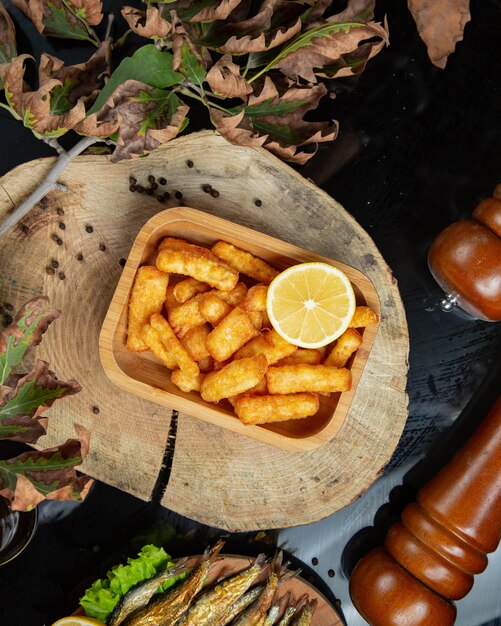 Top view of finger potato nuggets served with lemon