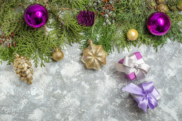 Top view fir branches xmas tree ornaments on grey background