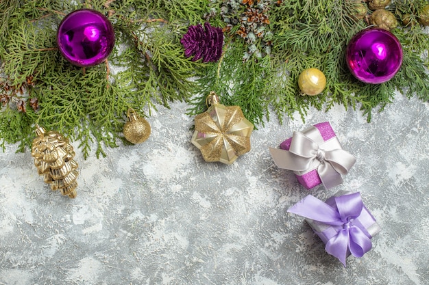 Top view fir branches xmas tree ornaments on grey background