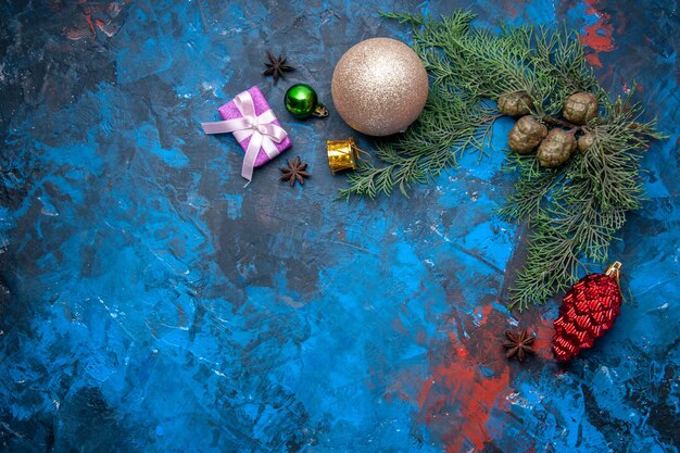 Top view fir tree branches cones xmas tree toys on blue background