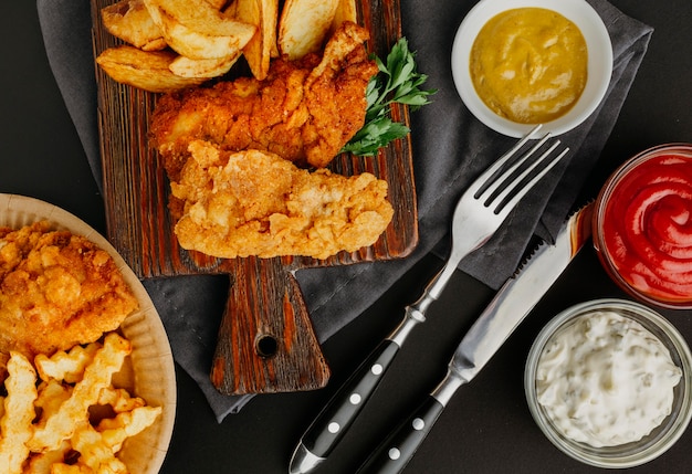 Top view of fish and chips with assortment of sauces