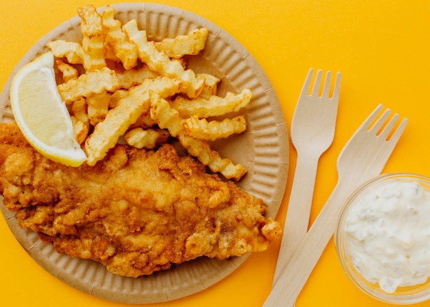 Top view of fish and chips with forks and lemon