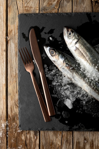 Top view of fish on slate with cutlery