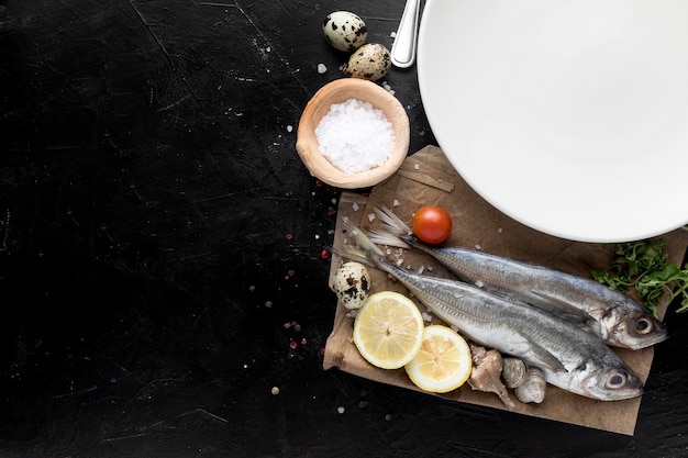 Foto gratuita vista dall'alto di pesce con limone e piatto