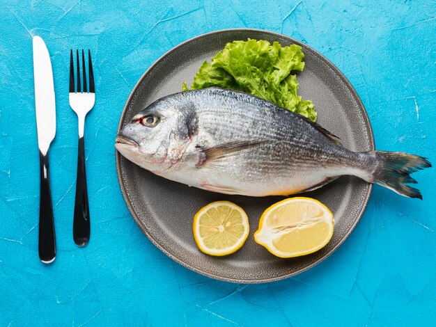 Top view fish with lemon on plate