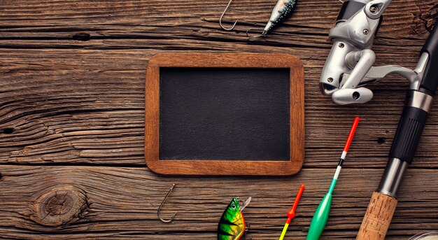 Top view of fishing essentials with blackboard and copy space