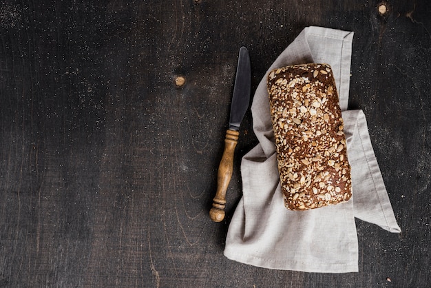 Вид сверху ароматный хлеб на ткани и нож