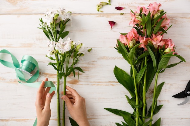 Top view florist hands making bouquet