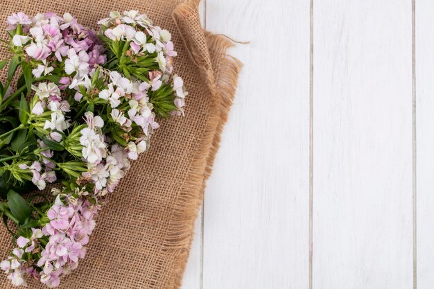 Top view of flowers on a beige napkin white surface