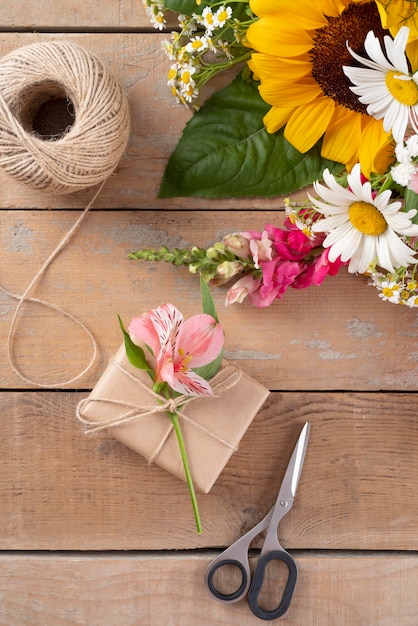 Foto gratuita vista dall'alto del bouquet di fiori con regalo