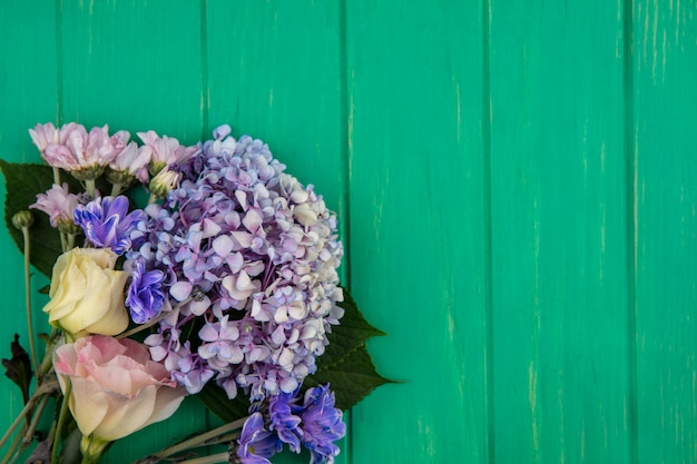 Free photo top view of flowers on green background with copy space