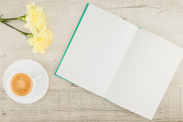 Top view flowers with book on wooden background