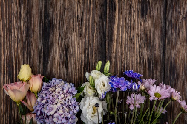 Top view of flowers on wooden background with copy space