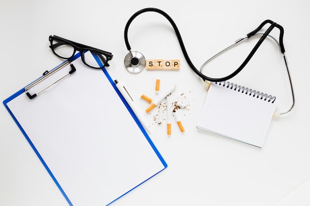 Free photo top view folder with cigarettes and stethoscope