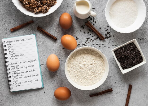 Top view of food ingredients with notebook and dessert mix