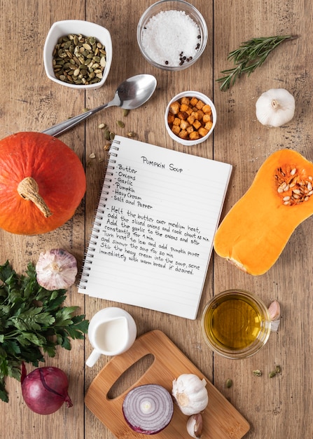 Top view of food ingredients with notebook and pumpkin