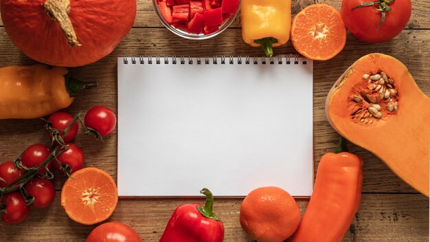 Top view of food ingredients with notebook veggies