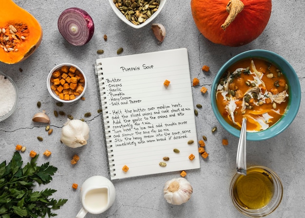 Top view of food ingredients with veggies and notebook