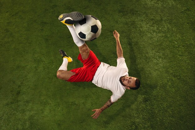 Top view of football or soccer player on green grass