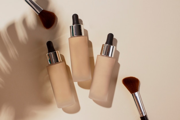 Free photo top view foundation containers and brushes