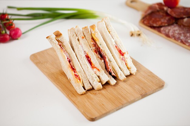 Top view of four club sandwiches on wooden board in the kitchen