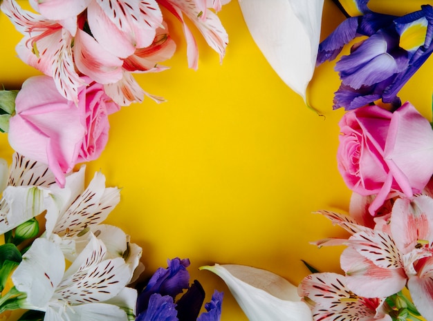 복사 공간 노란색 배경에 아름다운 꽃 핑크 장미 alstroemeria 어두운 보라색 아이리스와 화이트 칼라 백합 색상으로 만든 프레임의 상위 뷰