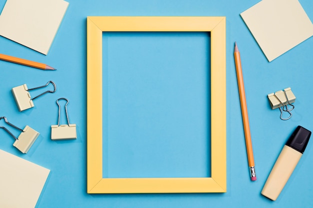 Top view frame surrounded by paper clips and marker