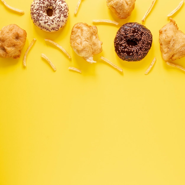 Top view frame with doughnuts and yellow background