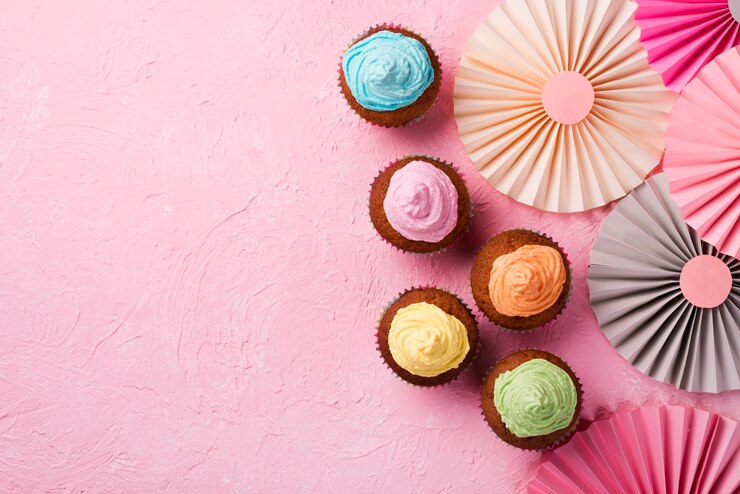Free Photo top view frame with glazed muffins on pink background