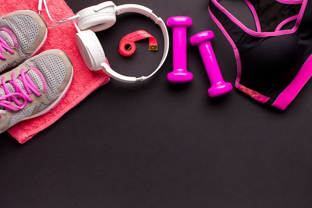 Top view frame with pink items and white headphones