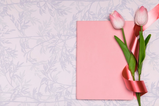 Top view frame with tulips and notebook