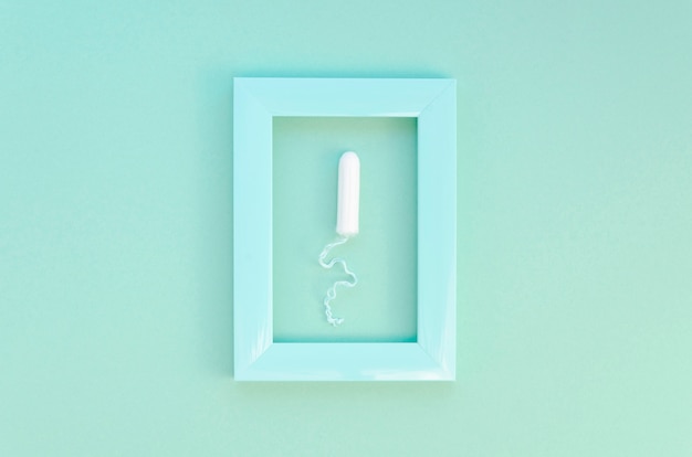 Free photo top view framed tampon on blue background