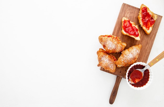 Vista dall'alto croissant francesi e marmellata di fragole copia spazio