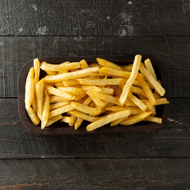 top view of french fries bowl on wooden surface