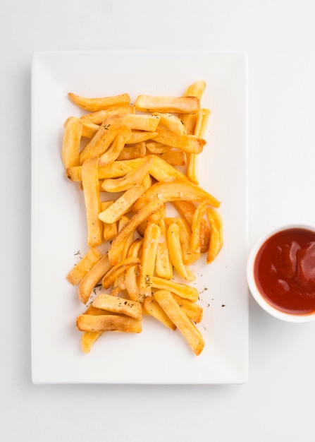 Top view of french fries on plate with ketchup sauce