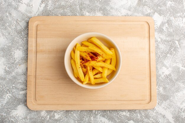 Top view of french fries with pepper inside white plate