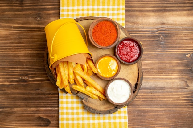 Top view of french fries with seasonings on wooden table