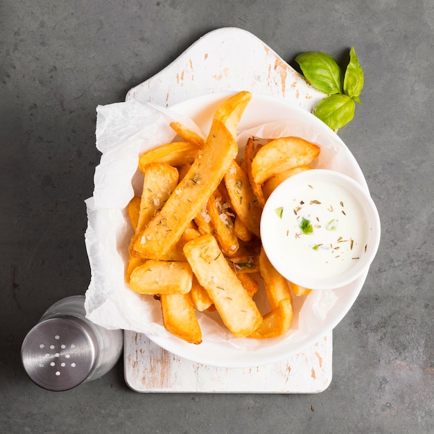 Top view of french fries with special sauce and herbs