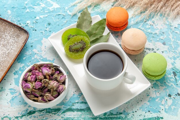 Top view french macarons delicious little cakes with cup of tea on blue surface cake bake biscuit sweet sugar pie tea