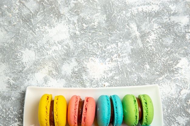 Free photo top view french macarons ful cakes on the white surface