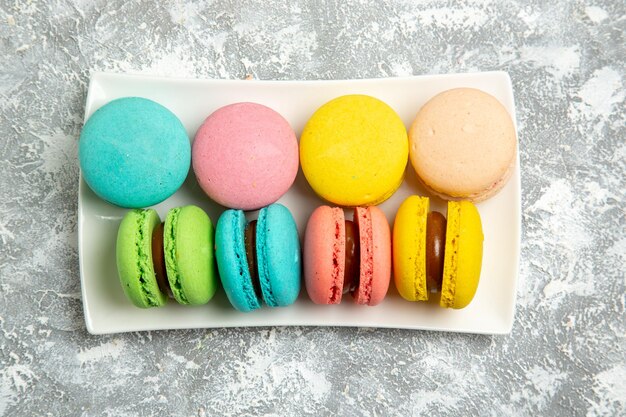 Top view french macarons ful cakes on white surface