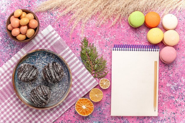 Foto gratuita vista dall'alto macarons francesi con torte al cioccolato sul rosa