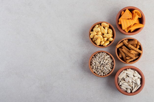 Top view of fresh appetizers inside bowls over grey background. 