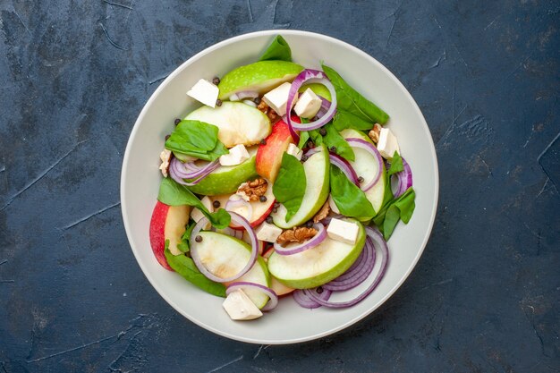 Top view fresh apple salad in bowl dark blue background