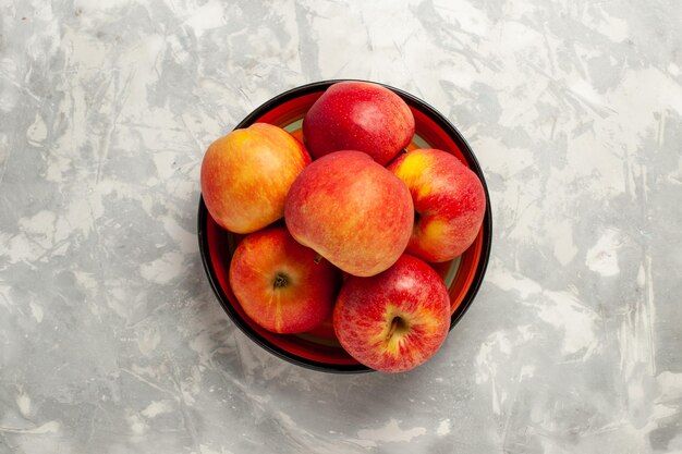 Top view fresh apples inside plate on white surface